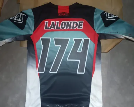 Dos d’un jersey de motocross à plat : le nom Lalonde et le numéro 174 ont été ajoutés en transfert DTF par-dessus les motifs du vêtement.